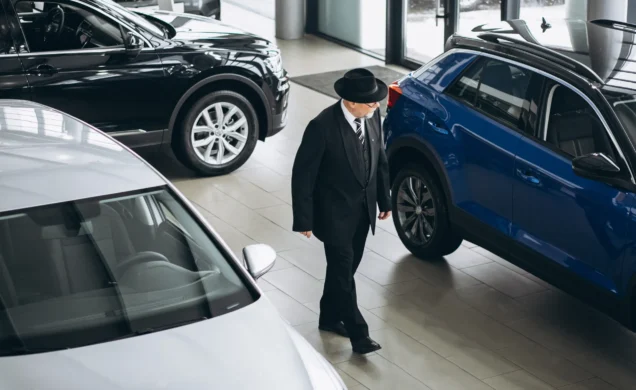 senior-man-car-showroom-choosing-car-scaled